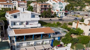 Et kysthotel med flere balkoner, beliggende ved stranden, og et poolområde.