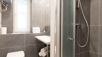 A modern bathroom with a shower, toilet, and sink.
