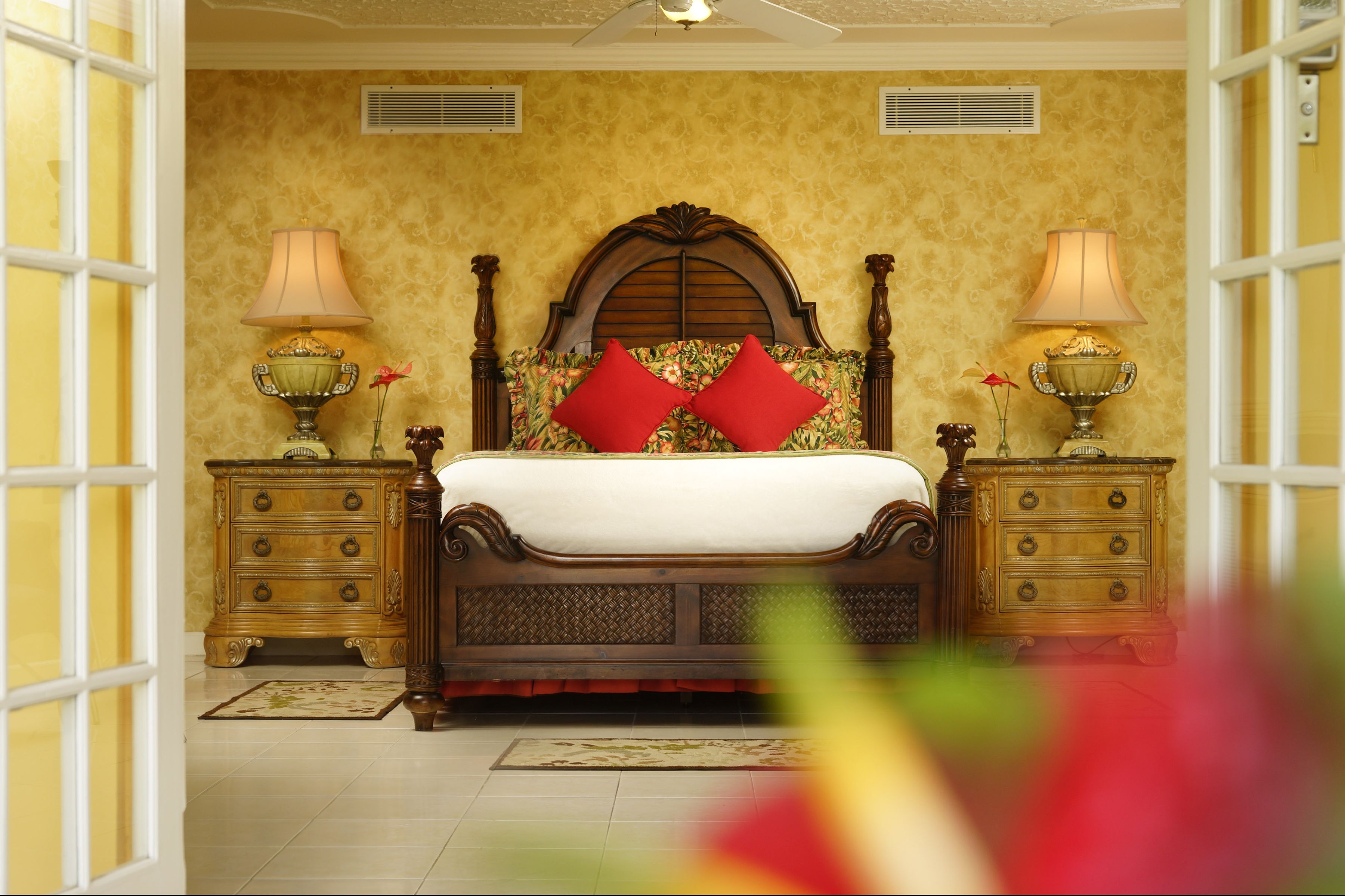 A bedroom with a wooden bed, two nightstands, and a floral-patterned headboard.