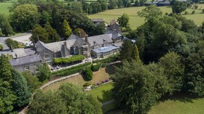 A large, historic house with multiple wings, surrounded by lush greenery and a well-maintained lawn. - Mitton Hall Country House Hotel (Clitheroe)