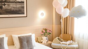 A hotel room with a large bed, a bedside table with a lamp, a framed picture on the wall, and a window with curtains. - Nota Bene Hotel (Lviv)