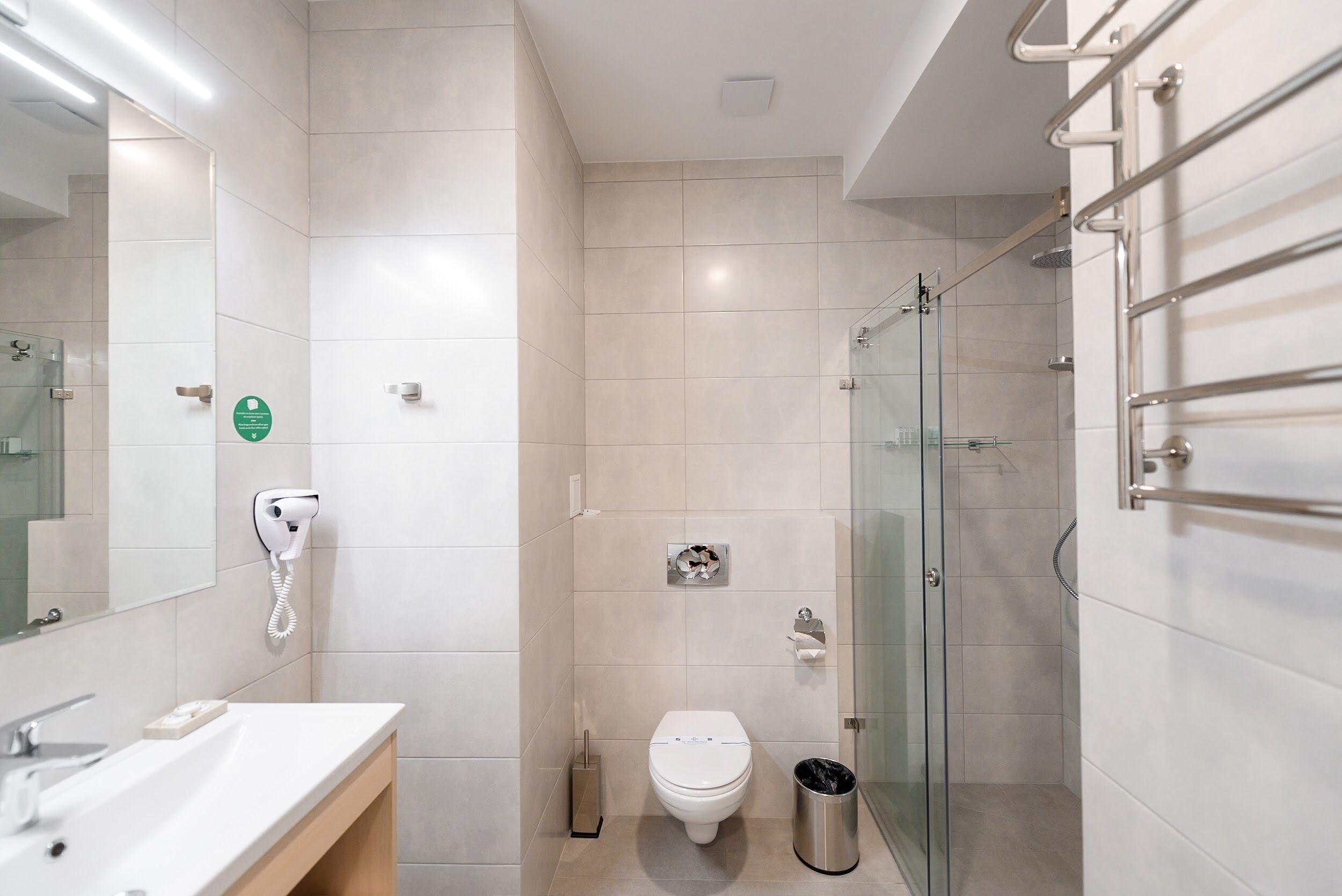 Un baño moderno con lavamanos, inodoro y cabina de ducha de vidrio.