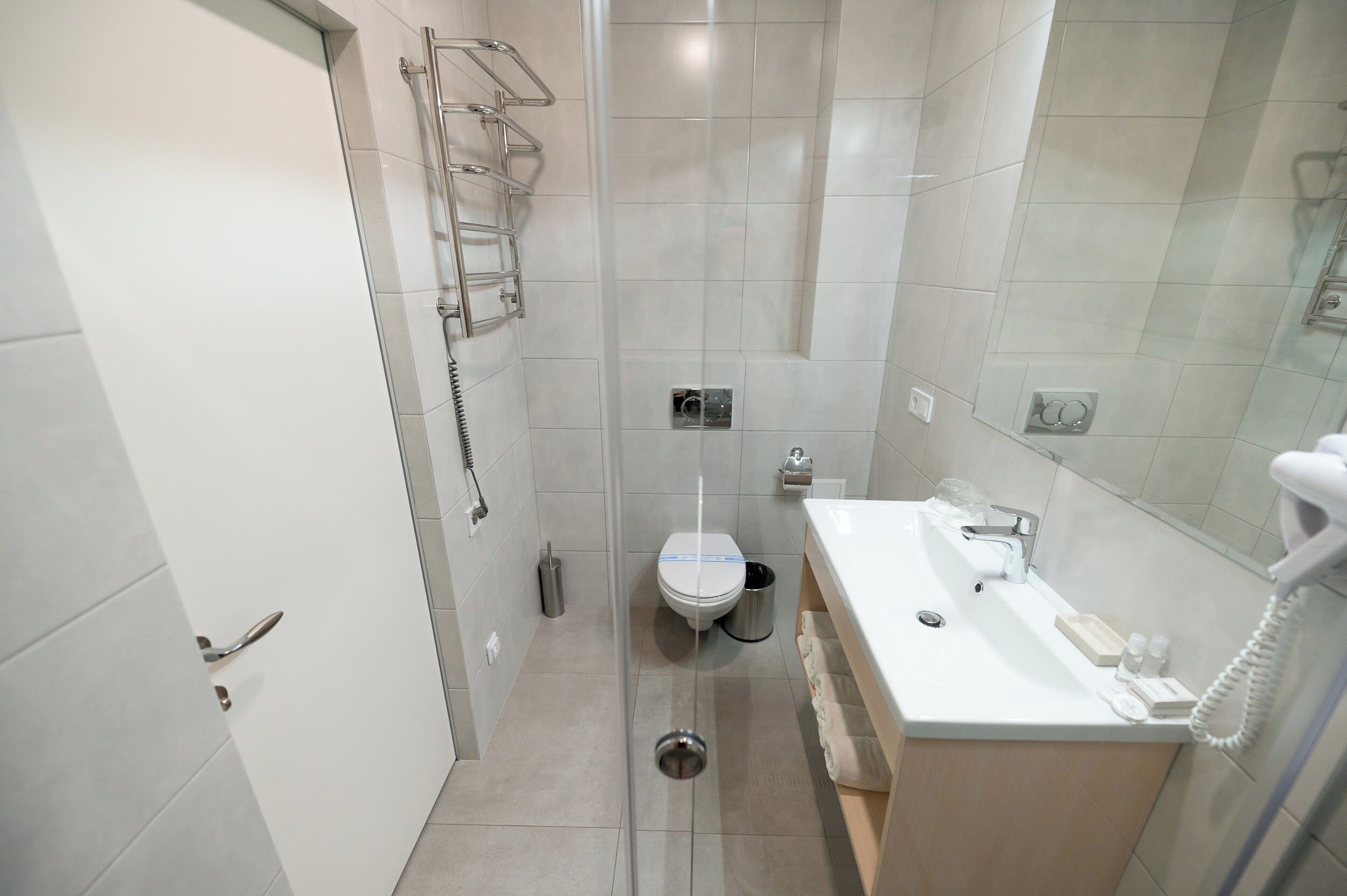 Un baño moderno con inodoro, lavamanos y ducha.