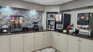 Eine moderne Küche mit Steinrückwand, einer Kaffeemaschine, einem Toaster und einem Kühlschrank.