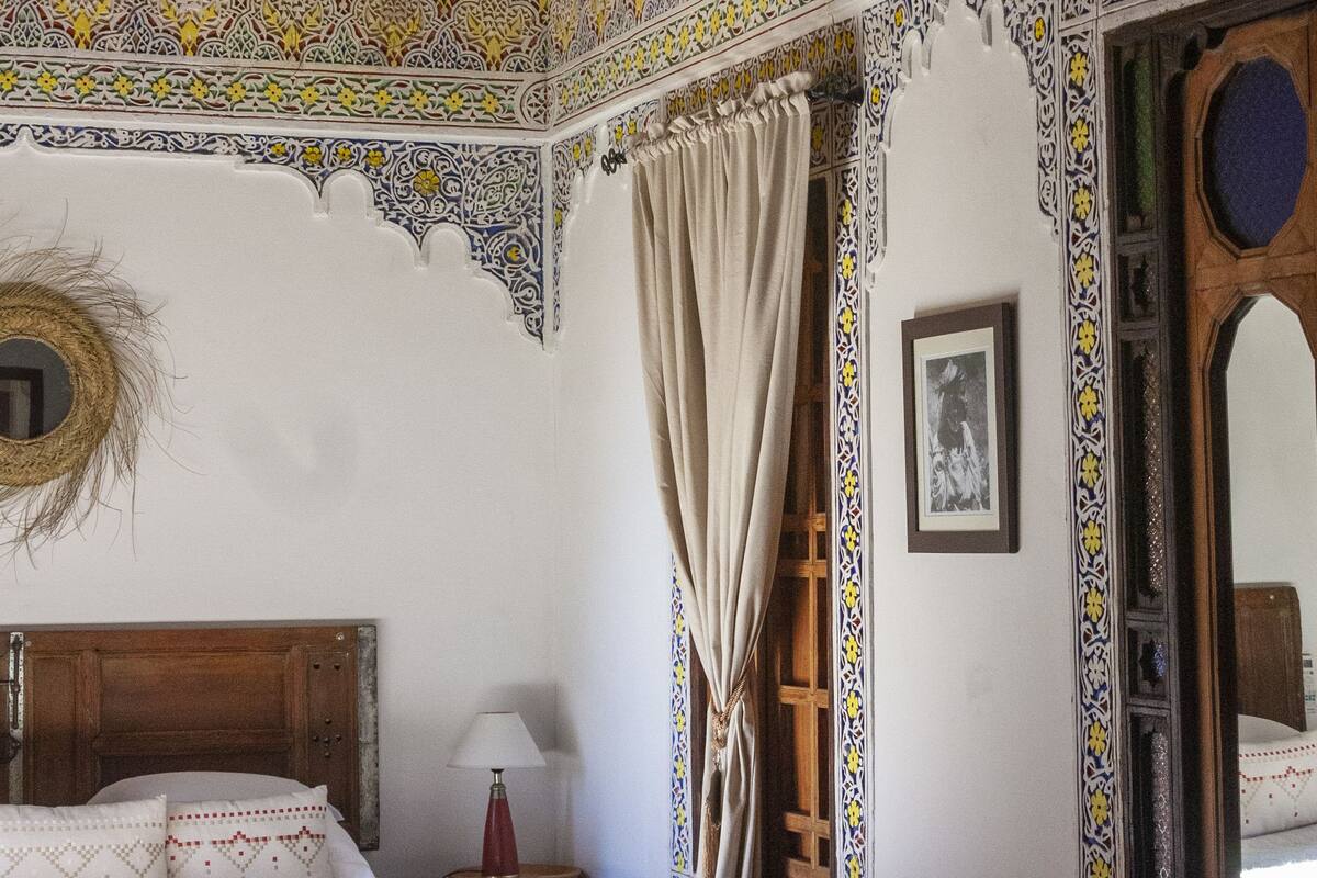 A room with a bed, a chair, and a table.