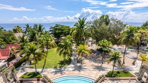 A resort pool area with multiple lounge chairs and a swimming pool. - Moulin Sur Mer (Saint-Marc)
