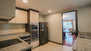 Una cocina con encimeras de granito, electrodomésticos de acero inoxidable y vistas a un comedor.