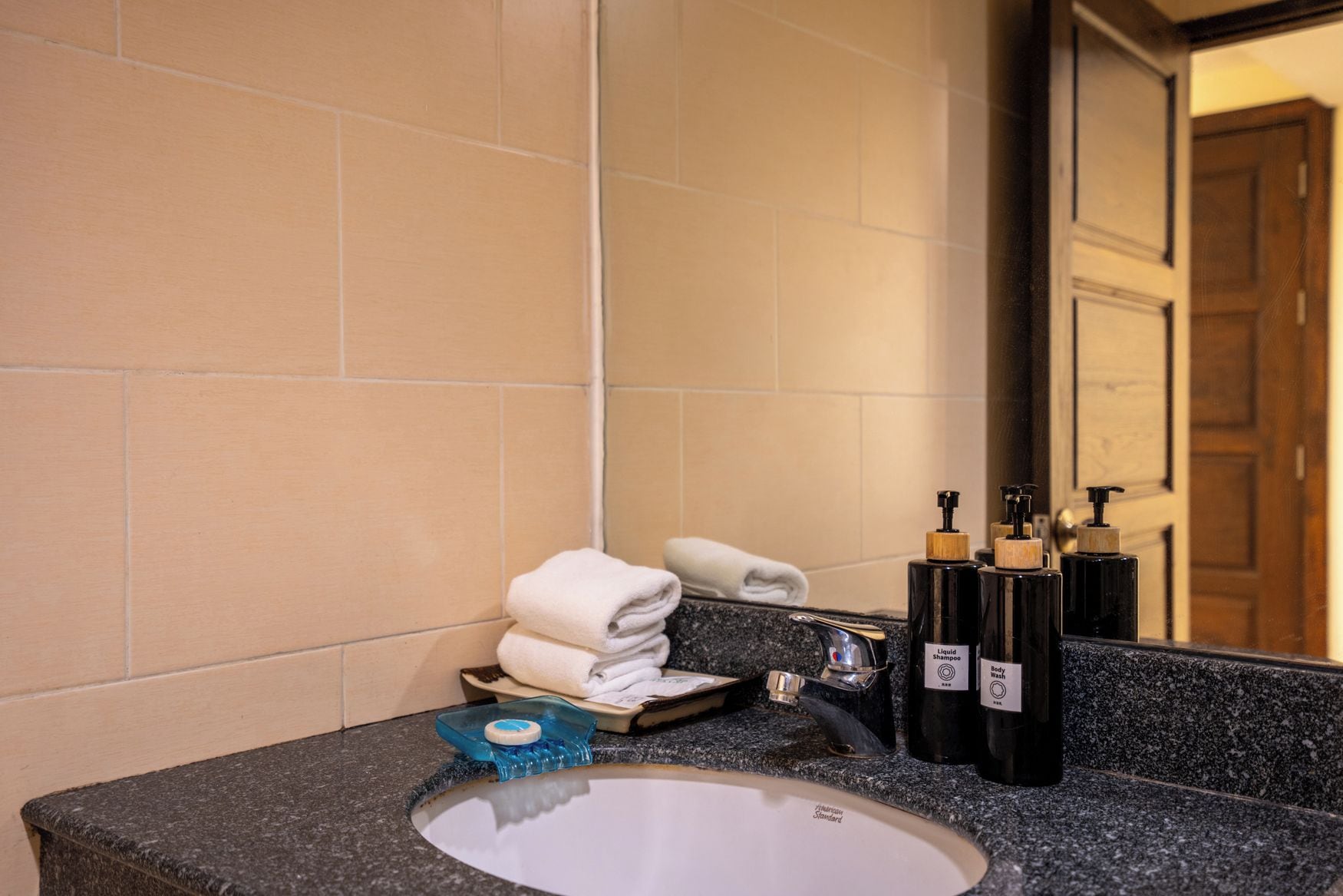 A bathroom with a sink, mirror, and toiletries.