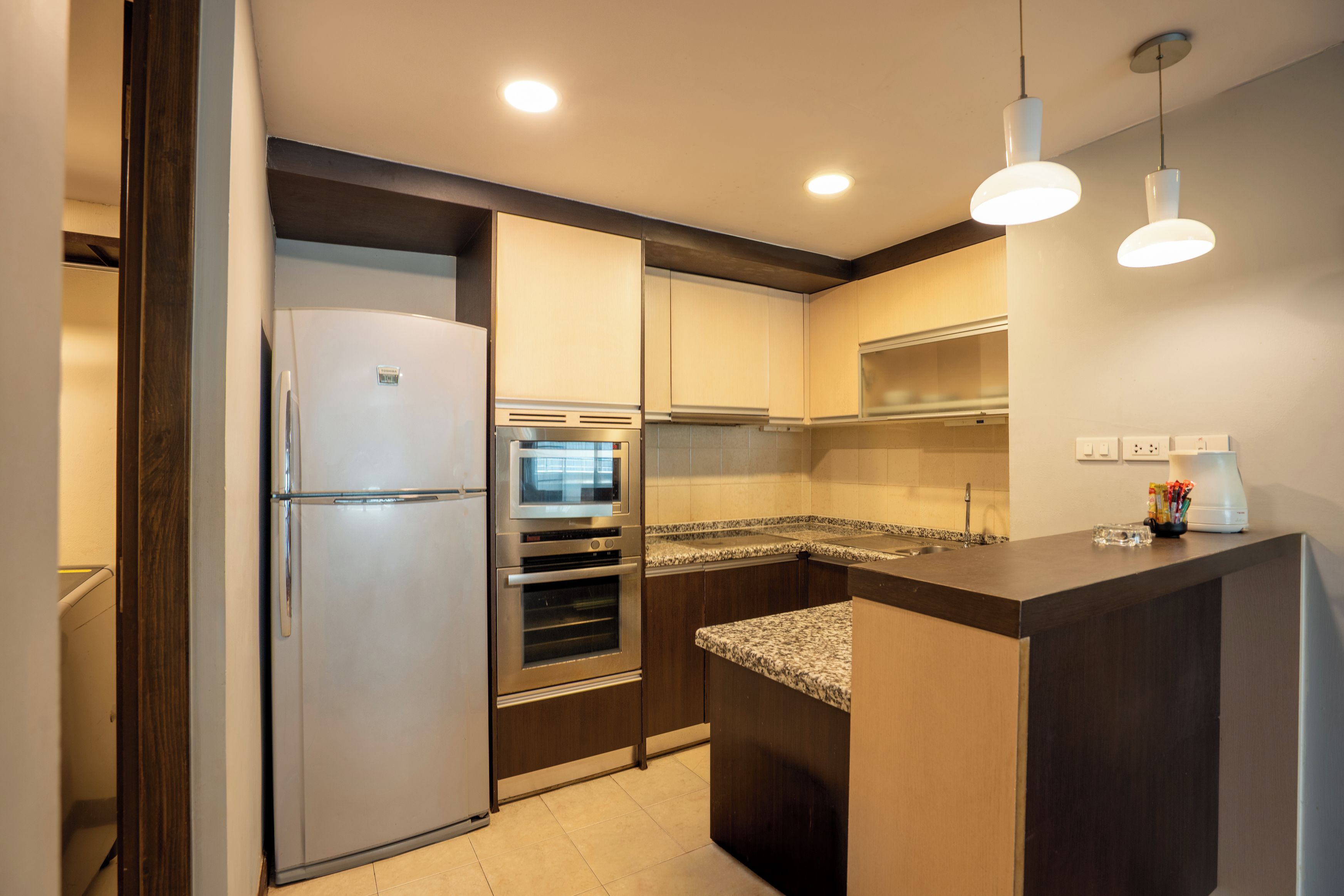 A modern kitchen with a refrigerator, oven, and microwave.
