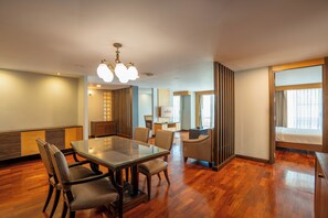 A hotel room with a dining area, a sofa, a desk, and a bed. - The Mercer Sukhumvit 4 (Bangkok)