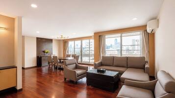 A spacious living area with a sofa, chairs, a coffee table, and a dining table.