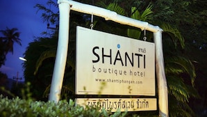 Een bordje voor Shanti Boutique Hotel, met een website-URL en Thaise tekst.