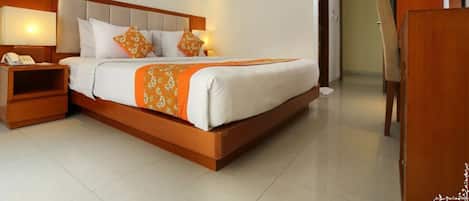 Habitación de hotel con una cama grande, una mesita de noche con teléfono, un cuadro en la pared y un armario de madera.