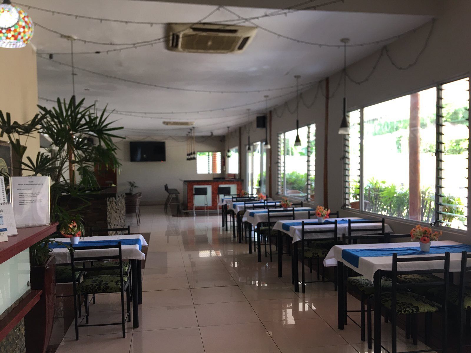 Un restaurante con varias mesas, sillas y una barra.