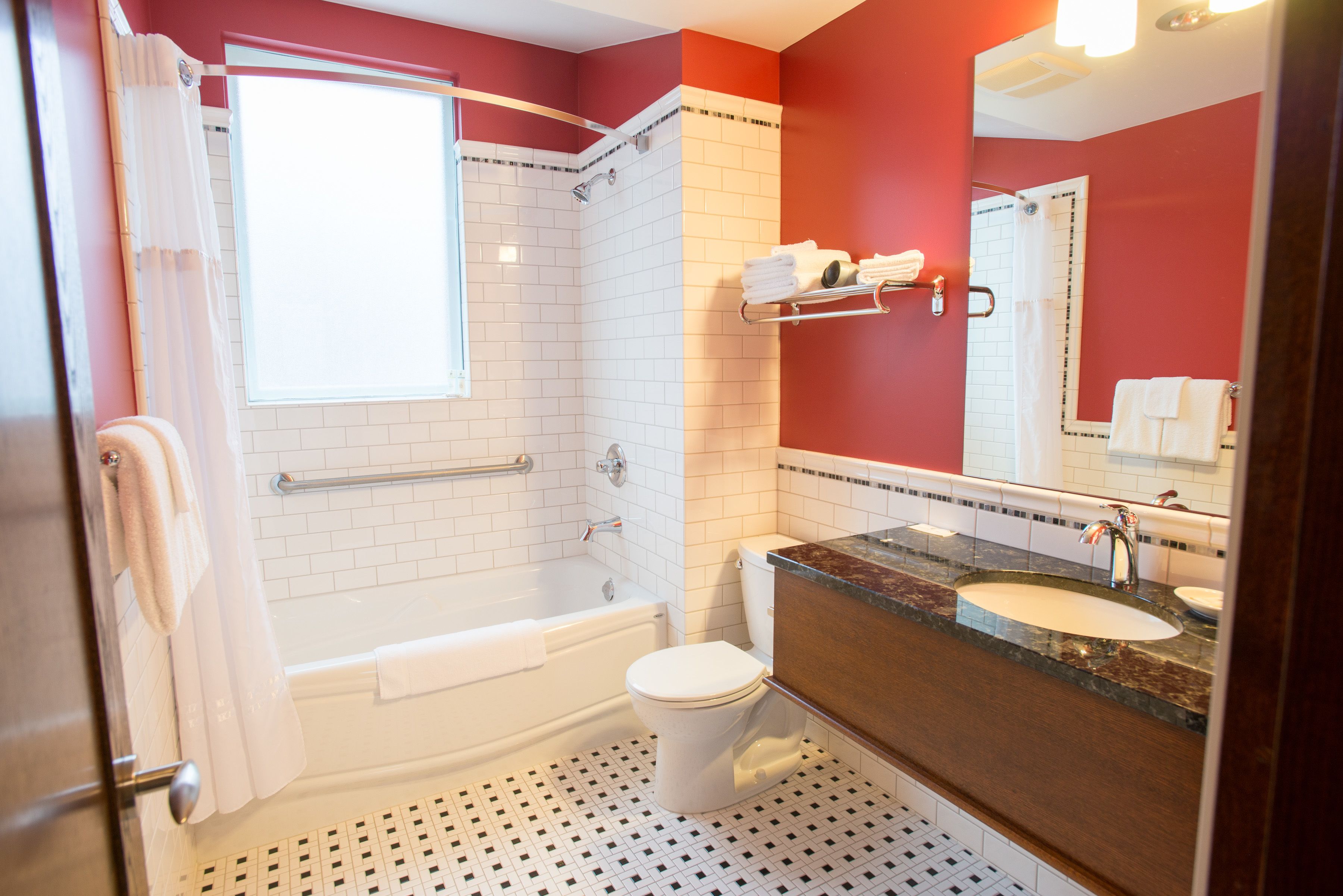 Une salle de bain avec une baignoire blanche, des toilettes blanches, un lavabo avec un miroir et un espace douche.
