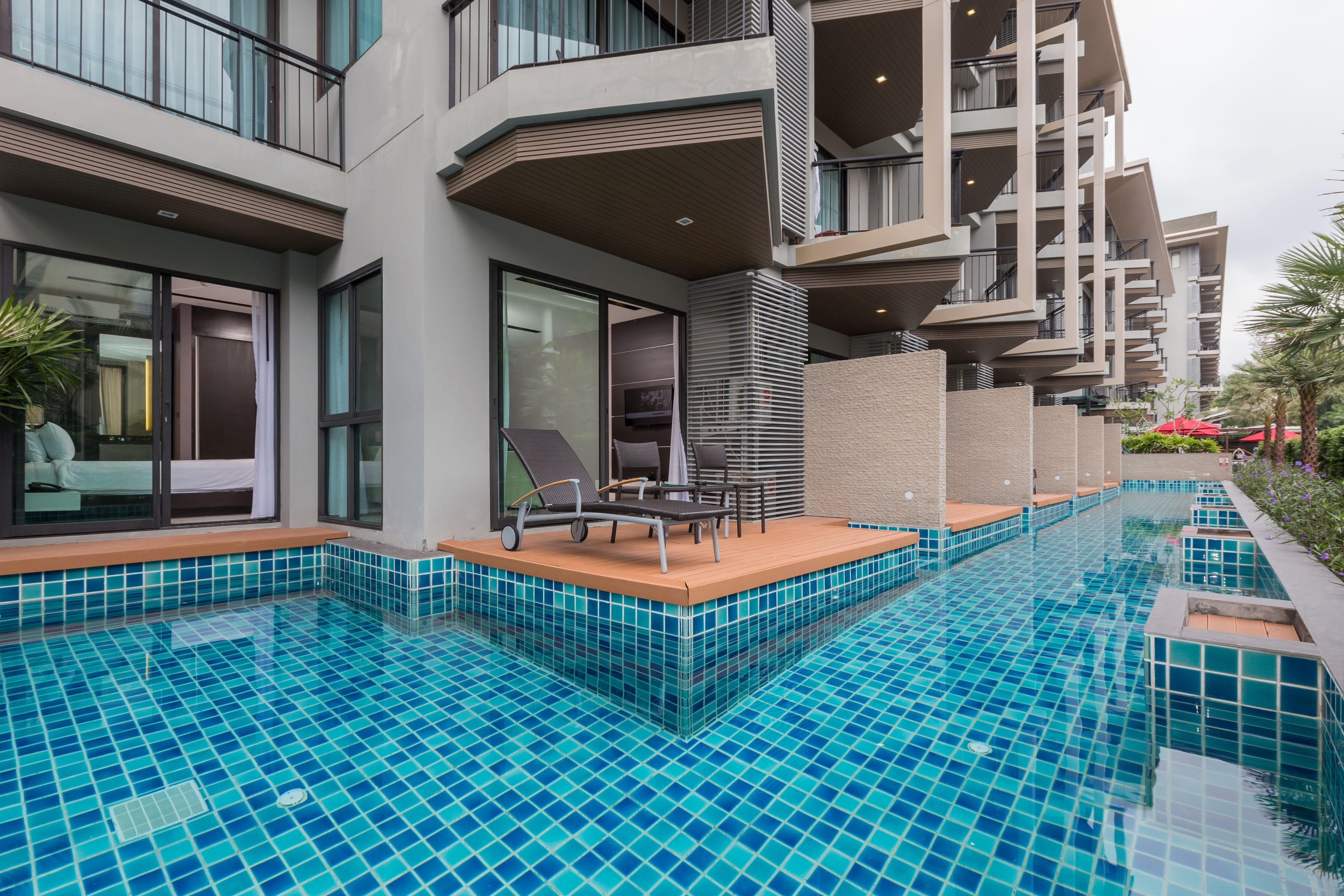 Un hôtel moderne doté d’une piscine, d’un espace extérieur aménagé et de balcons.