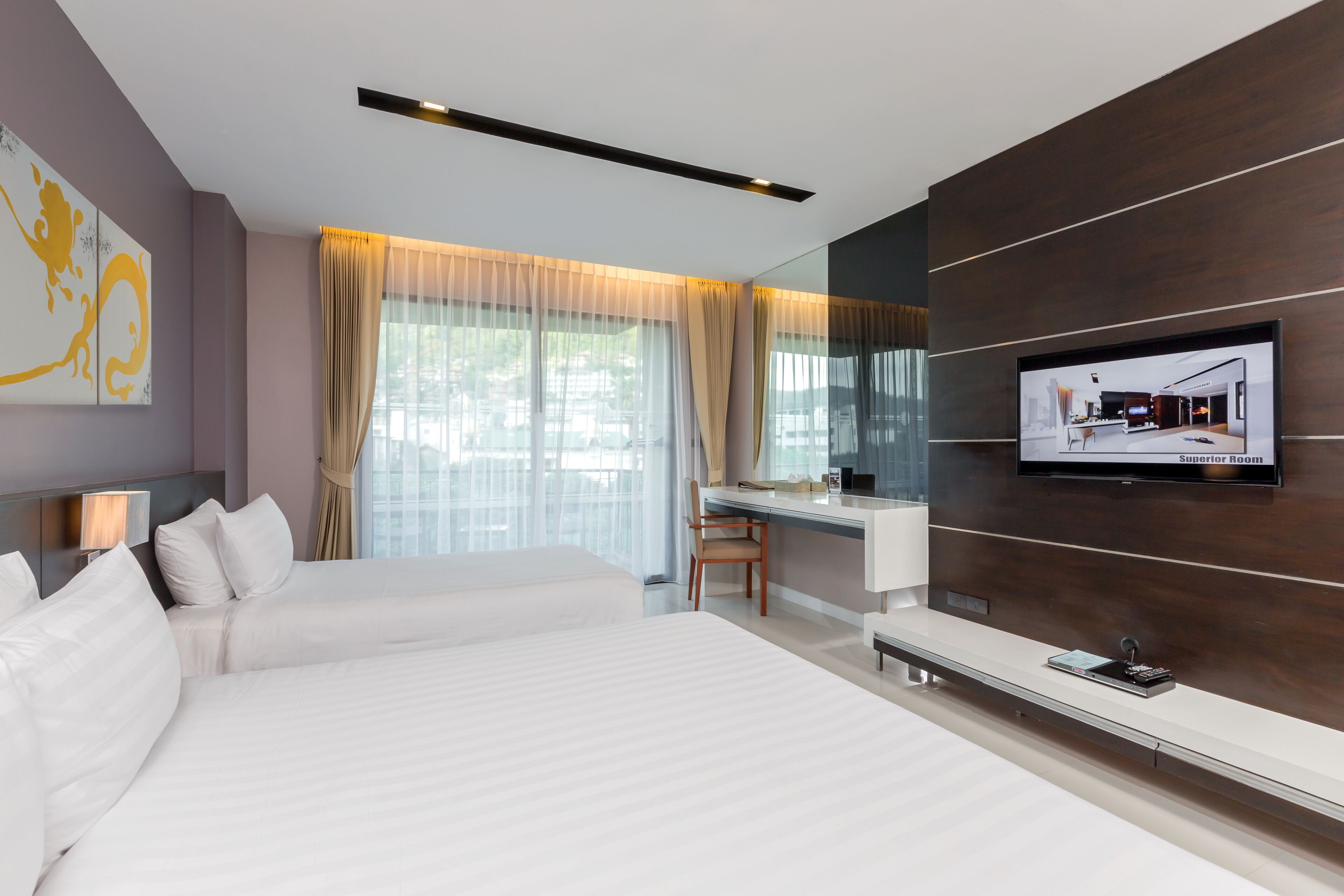 Habitación de hotel moderna con una cama grande, un escritorio y un televisor montado en la pared.