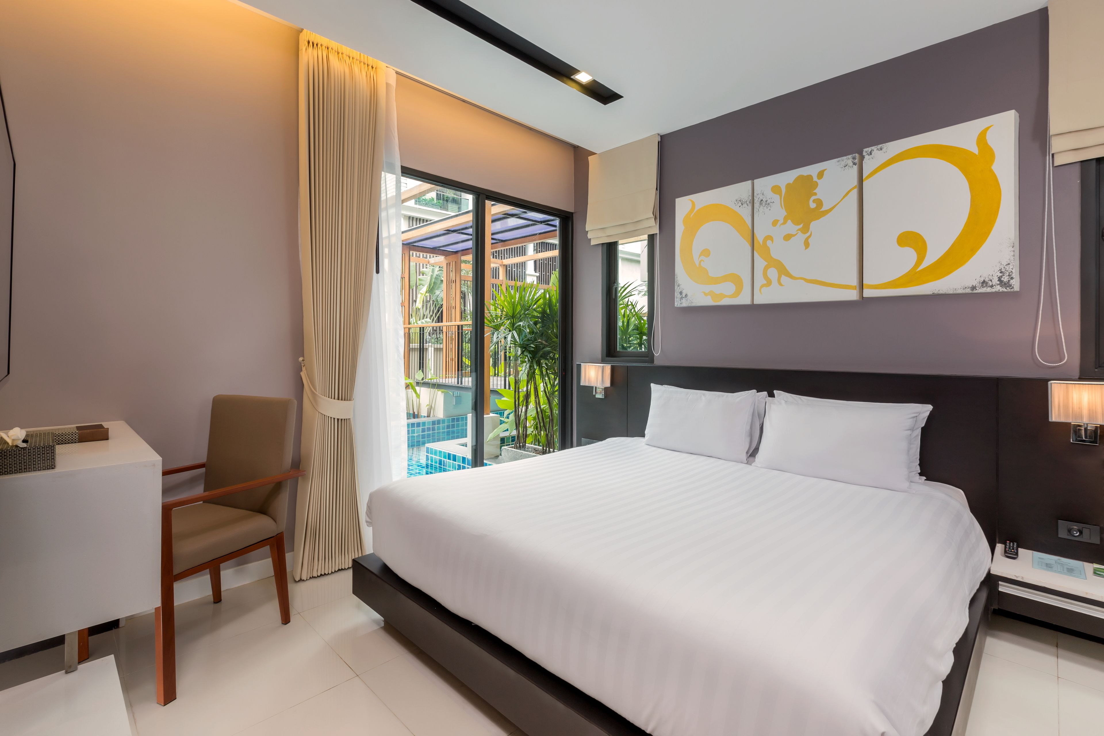 Una habitación de hotel moderna con una cama grande, un escritorio y vistas a la piscina exterior.