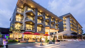 Un hotel de varios pisos con terraza al aire libre y piscina.