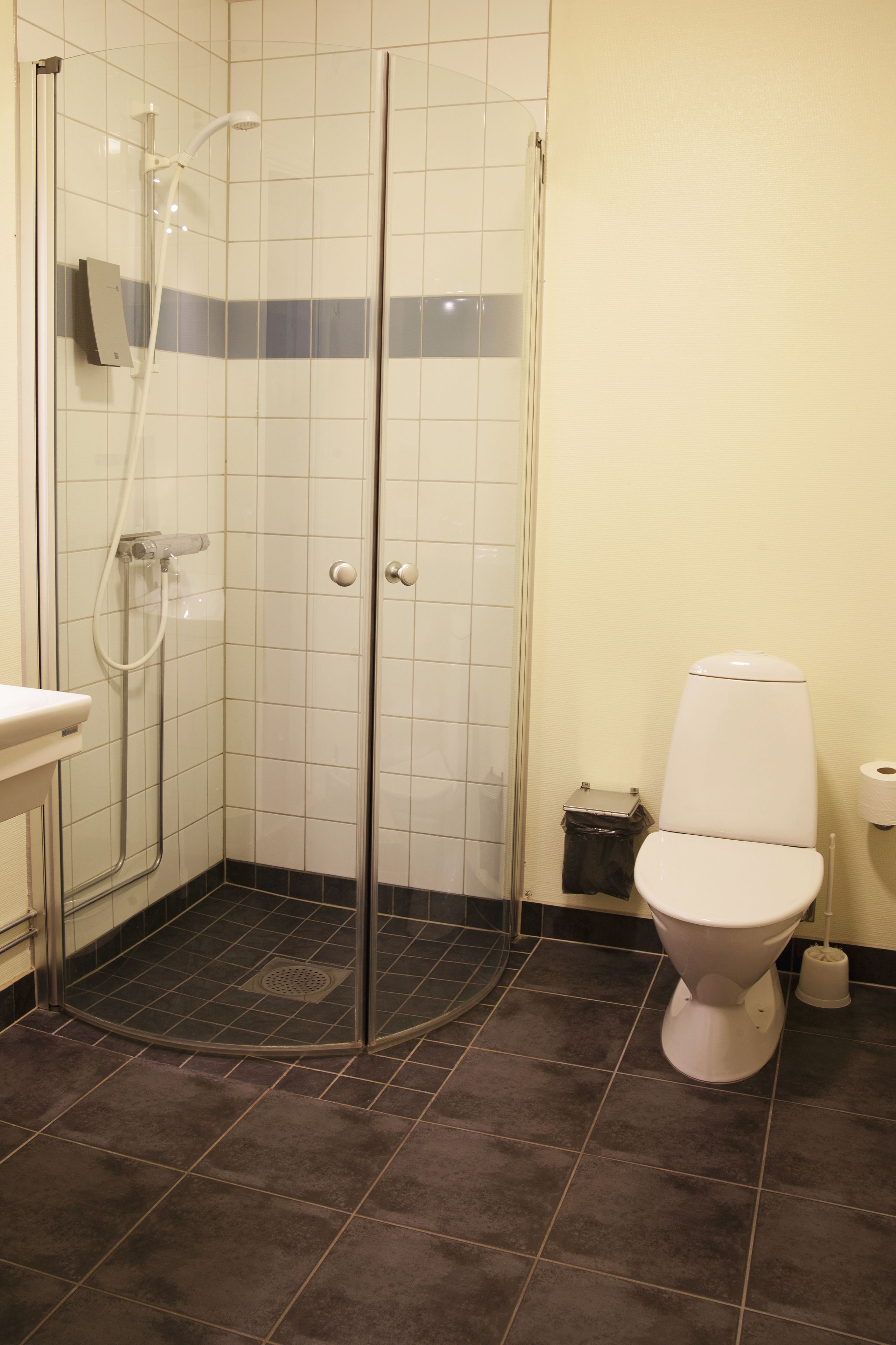 Un baño con ducha, inodoro y lavabo.