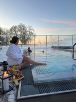 Una piscina cubierta, una piscina al aire libre, tumbonas
