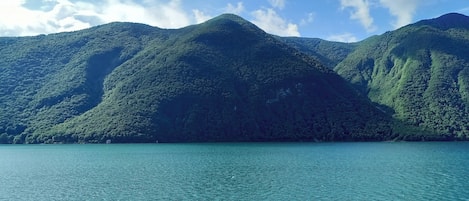 Een bergachtig landschap met helder turquoise water op de voorgrond.