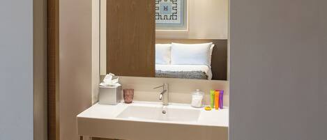 A modern bathroom with a white sink, mirror, and towel rack.