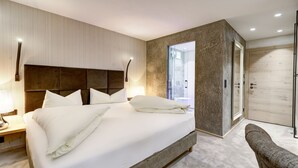 Une chambre moderne avec un grand lit, une table de chevet, une chaise et un dressing.