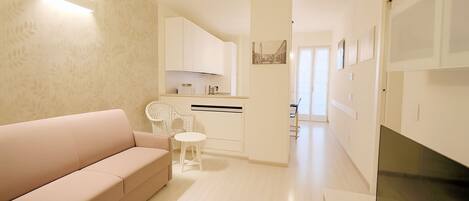 A modern living room with a sofa, a small table, and a TV.