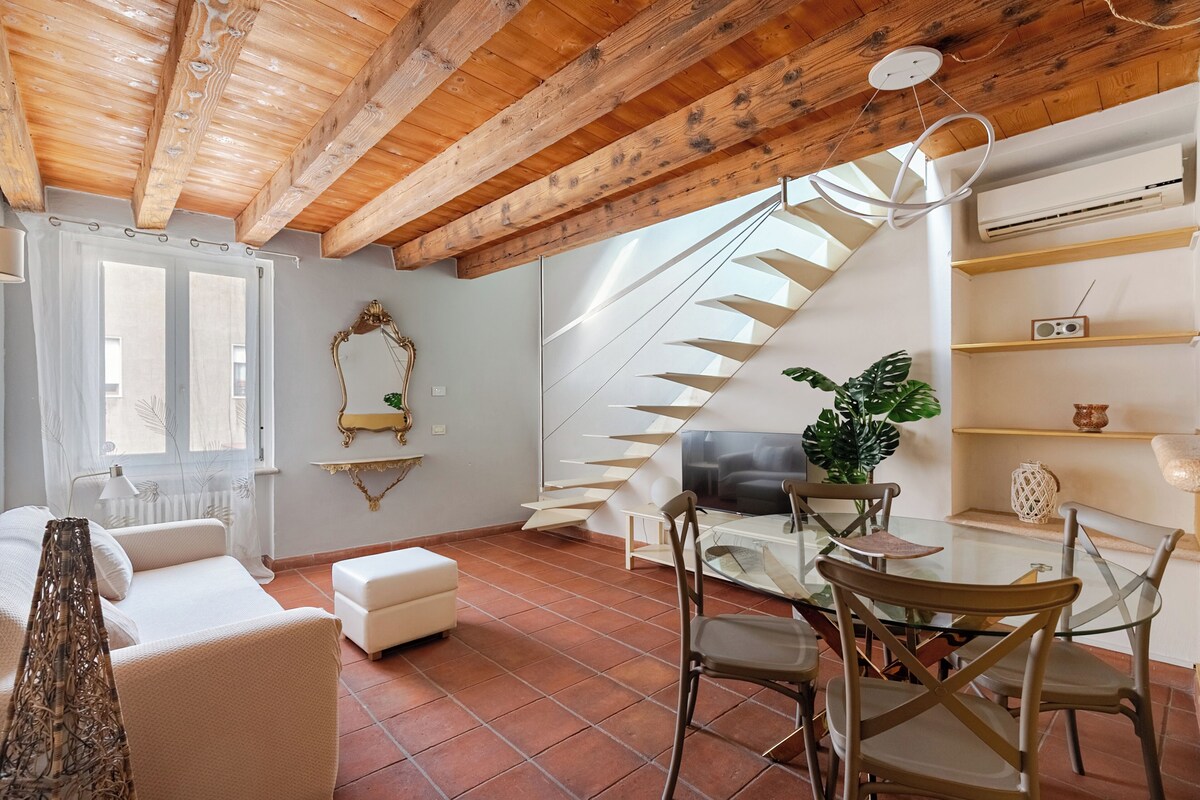 Una sala de estar con un sofá blanco, una mesa de comedor de cristal y un techo de madera.
