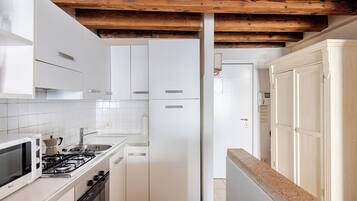 A kitchen with white cabinets, a stove, and a microwave.