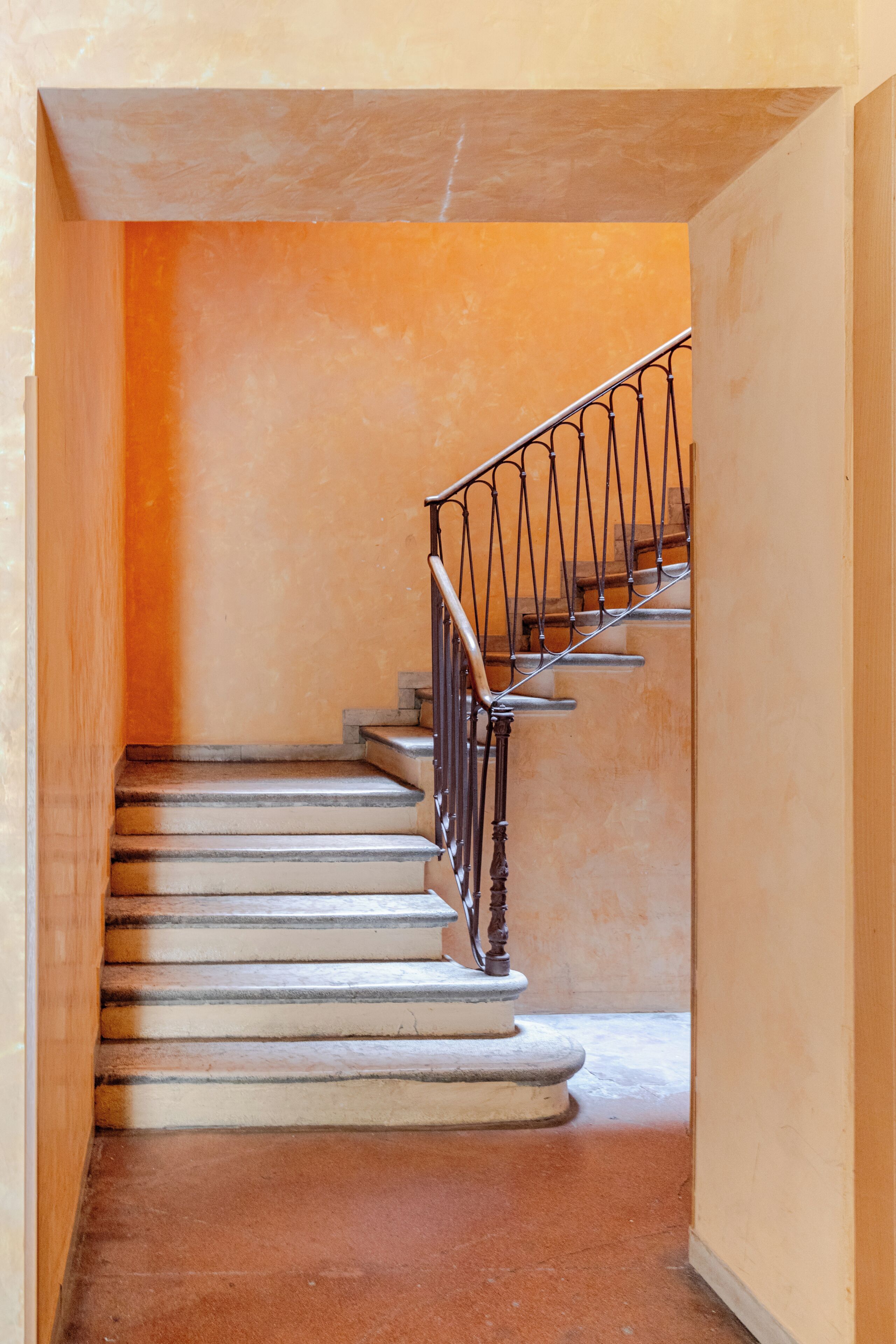 A staircase with a metal railing, leading to an upper floor.