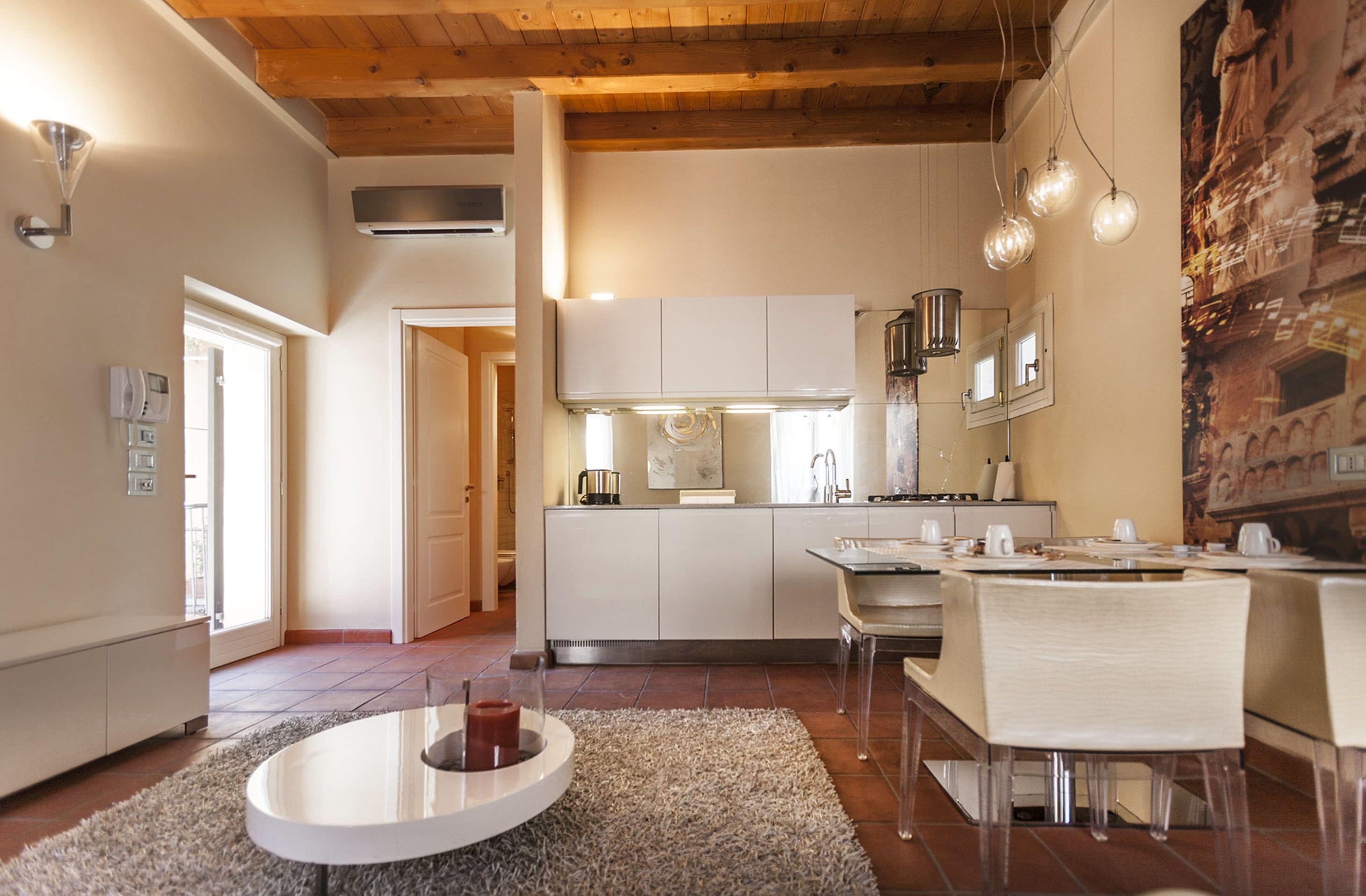 A modern kitchen with white cabinets, a dining area with a round table, and a cozy seating arrangement.