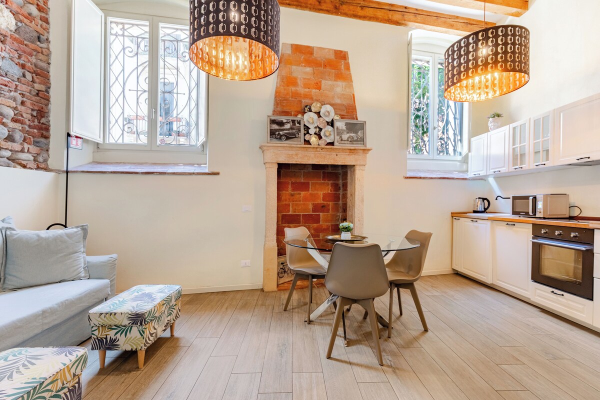 Una cocina moderna con chimenea de ladrillo, comedor y piso de madera.