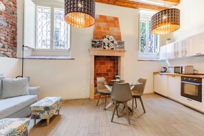 Una cocina moderna con chimenea de ladrillo, comedor y piso de madera.
