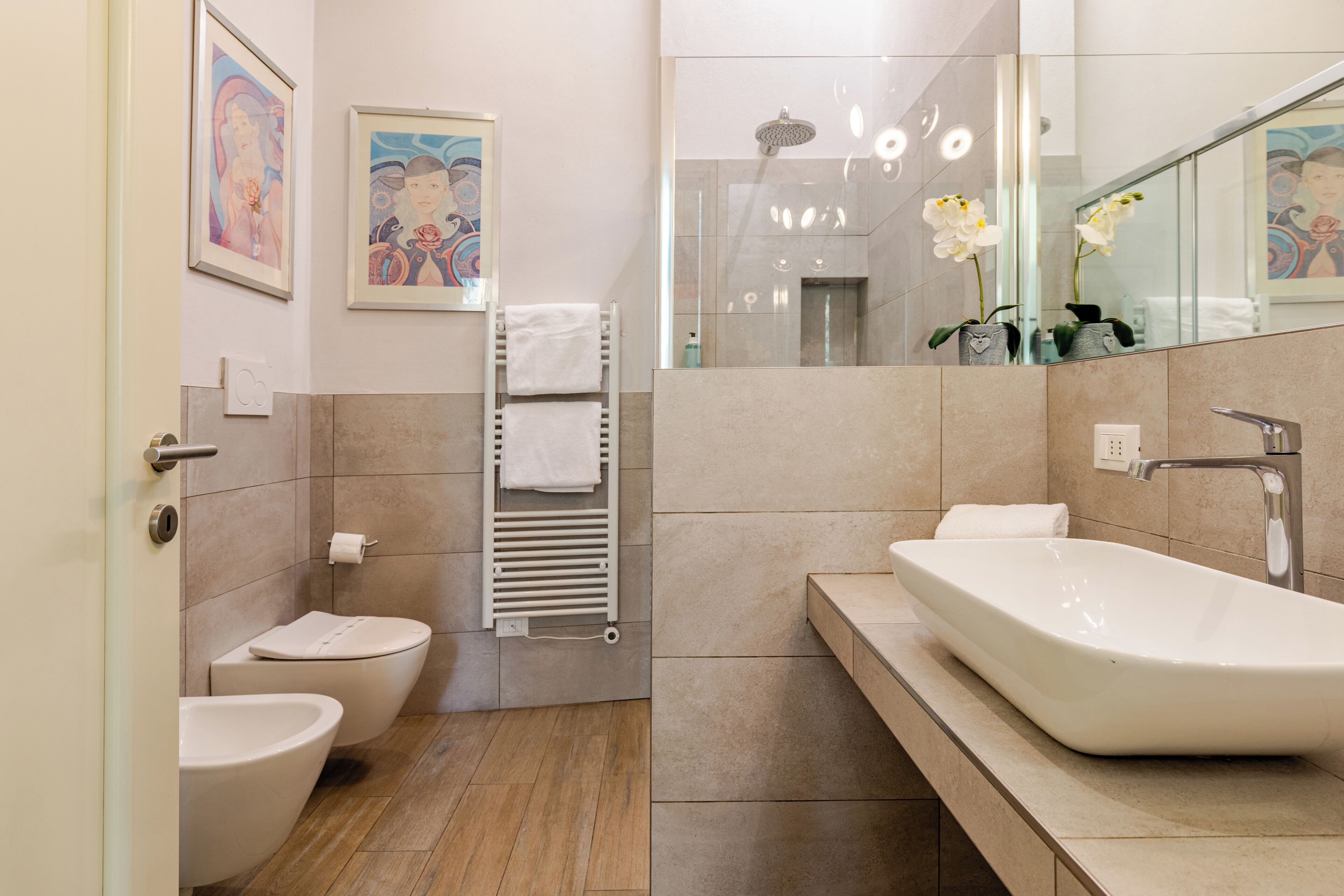 Une salle de bain moderne avec une baignoire sur pieds, des toilettes et un bidet.