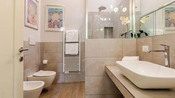 Une salle de bain moderne avec une baignoire sur pieds, des toilettes et un bidet.