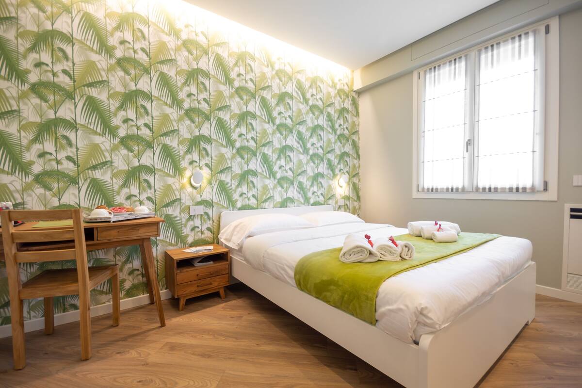 A bedroom with a bed, a desk, and a chair.