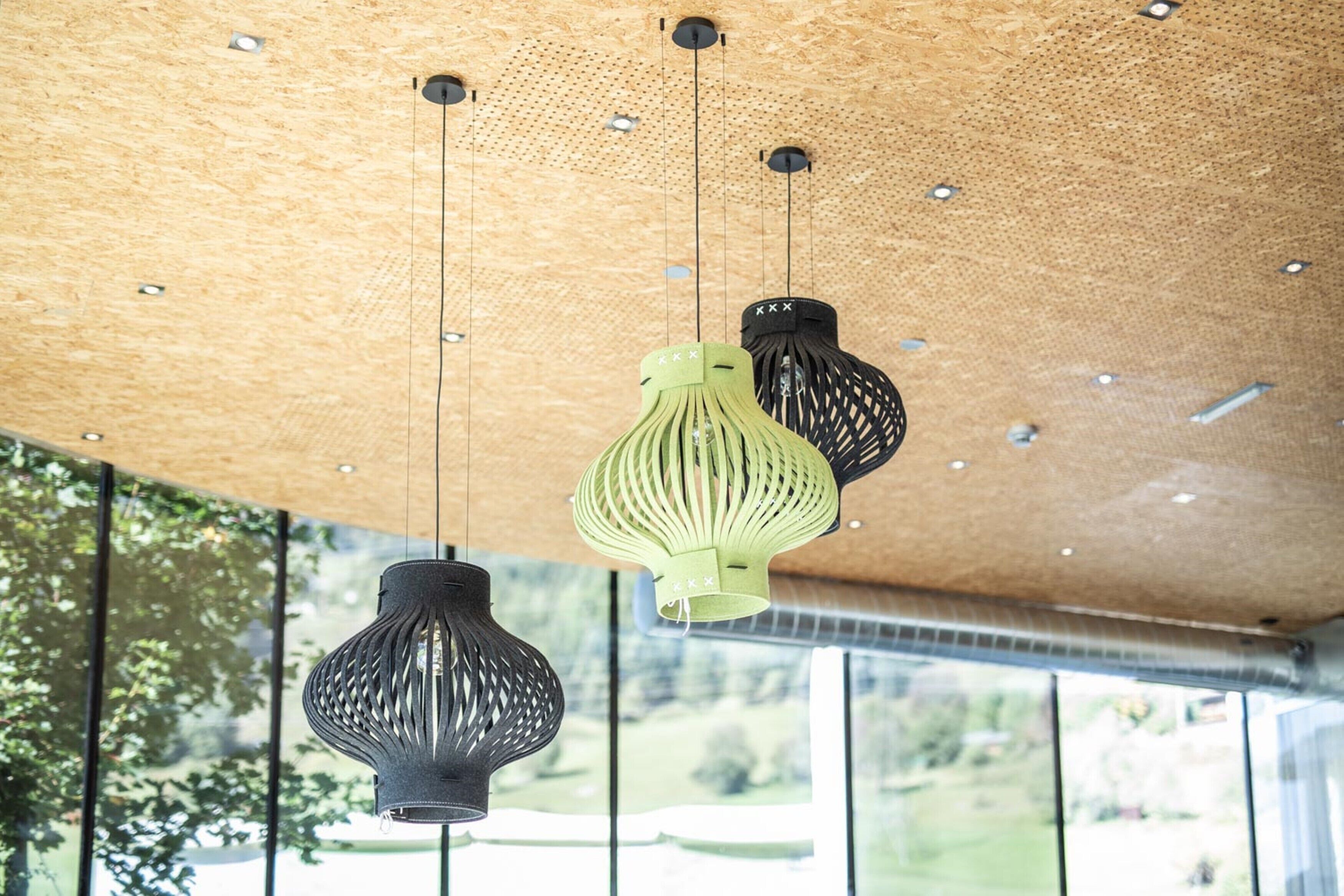 A ceiling with three hanging pendant lights and a wooden panel.