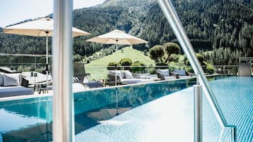Una piscina al aire libre, sillones reclinables de piscina