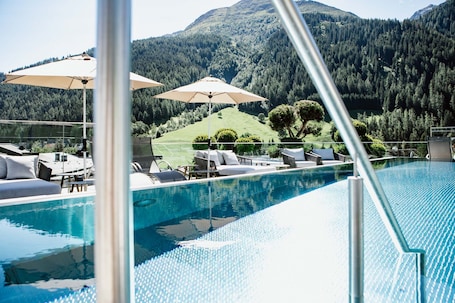 Una piscina al aire libre, sillones reclinables de piscina