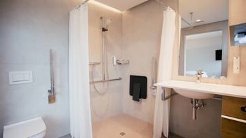 Un baño moderno con ducha, inodoro y lavabo.