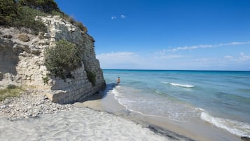 Plage privée, sable noir, chaises longues, parasols