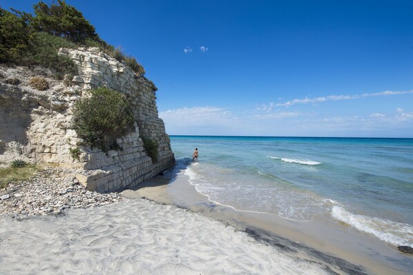 Playa privada, playa de arena negra, camastros y sombrillas 