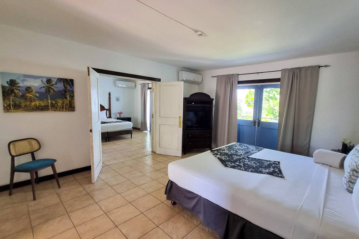 Une chambre d’hôtel avec un lit, une chaise, une télévision et un tableau au mur.