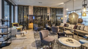 Un interno moderno con una cantina per vini, posti a sedere confortevoli e una vista attraverso ampie finestre.
