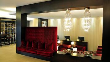 Un vestíbulo de hotel moderno con un sofá rojo, un mostrador de recepción y una exhibición de zapatos.