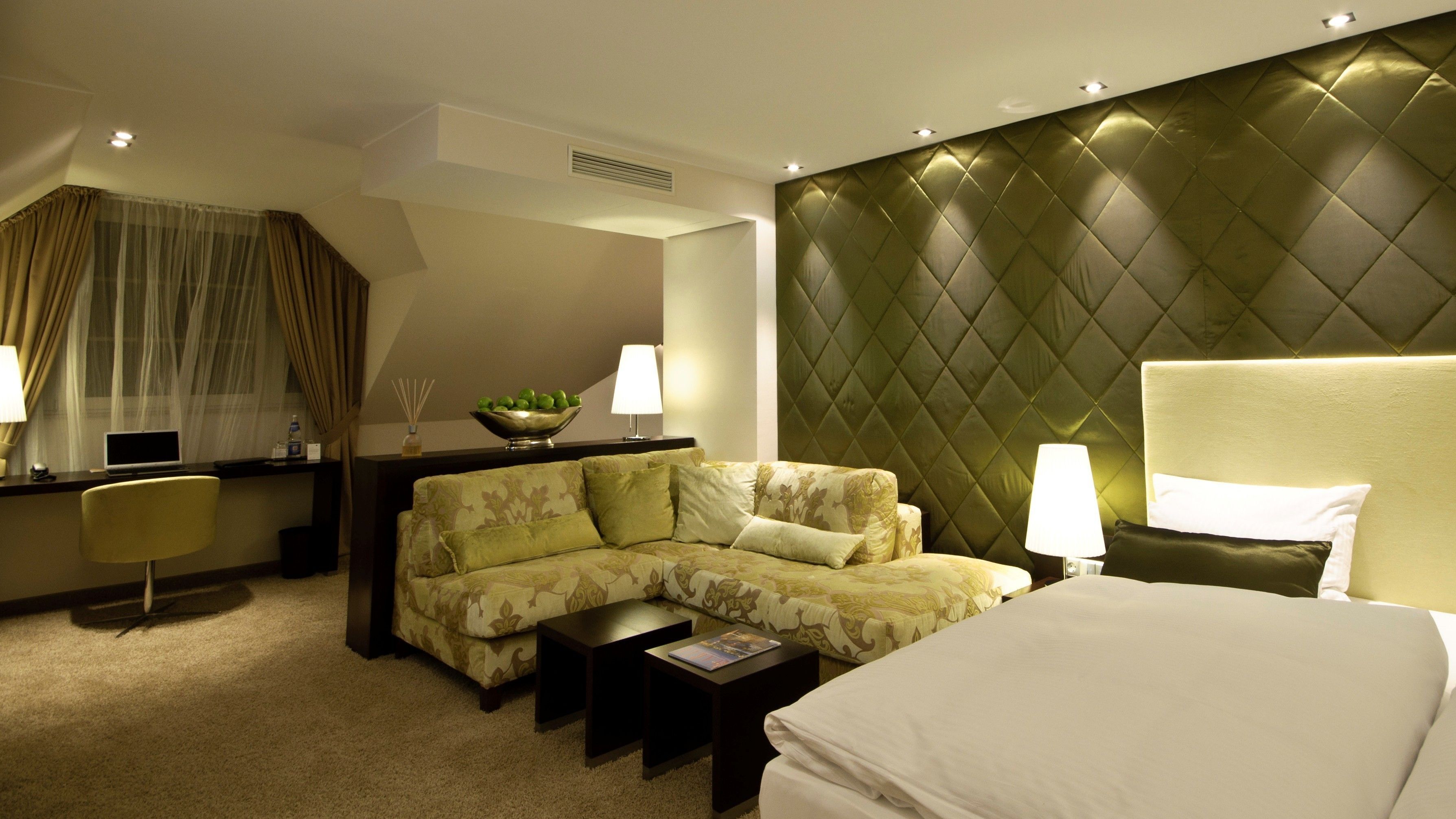 Ein Hotelzimmer mit einem Bett, einer Couch, einem Schreibtisch und einem Sessel.