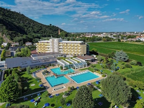 A hotel with multiple swimming pools, a large garden, and a view of the surrounding landscape. - Hotel Terme Leonardo (Abano Terme)