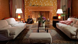 A living room with two sofas, a coffee table, a fireplace, and lamps.